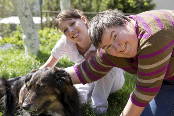 two women and a half breed dog